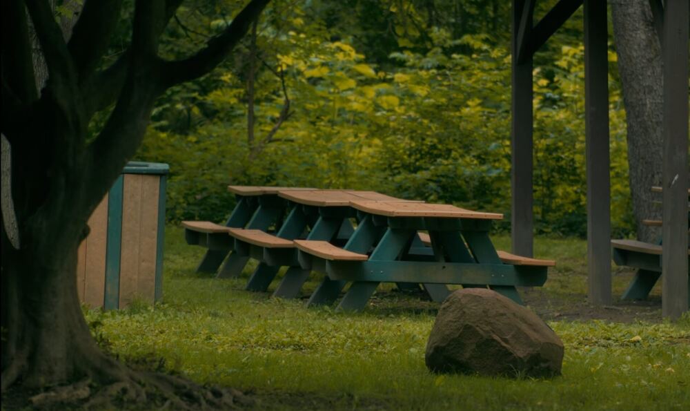 Empty picnic tables under a park pavilion